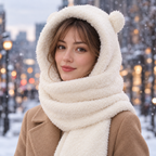 Woman in a camel coat wearing the white Teddy Hood on a snowy street